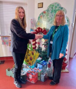 Emma Freeman presents food donations to Karen Walker.
